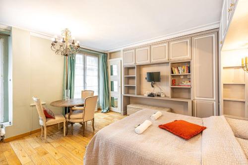 - une chambre avec une table et un lit ainsi qu'une salle à manger dans l'établissement GuestReady - Lux Studio - In Le Marais, à Paris