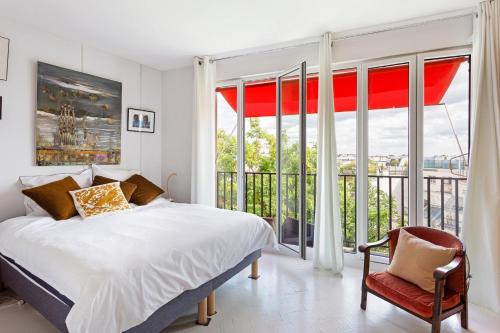 une chambre avec un lit et une grande fenêtre dans l'établissement GuestReady - Charmant Apt. près du Sacré-Cœur, à Paris