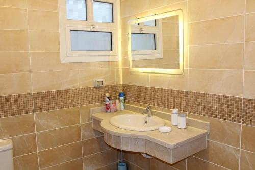 a bathroom with a sink and a mirror at Paradise Ras Sudr, Home in Raʼs Matarma