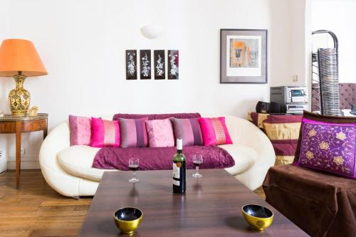 - un salon avec un canapé et 2 verres à vin sur une table dans l'établissement GuestReady - Très bel Appartement confortable, à Paris