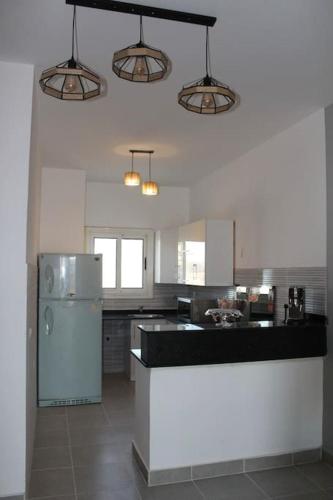 a kitchen with a refrigerator and a counter top at Paradise Ras Sudr, Home in Raʼs Matarma