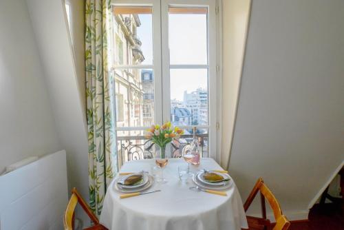 une table avec un chiffon de table blanc et une fenêtre dans l'établissement GuestReady - Apt lumineux près de la gare Ranelagh, à Paris