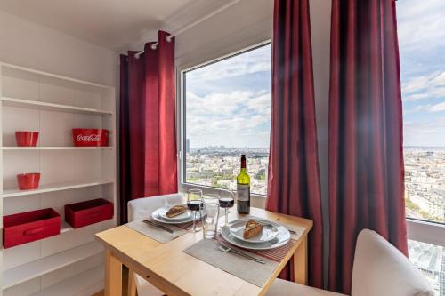 une salle à manger avec une table et une fenêtre dans l'établissement GuestReady - Beau studio avec vue imprenable, à Paris