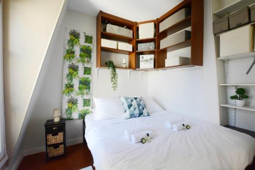 - une chambre avec 2 lits et une fenêtre ornée de plantes dans l'établissement GuestReady - Apt lumineux près de la gare Ranelagh, à Paris