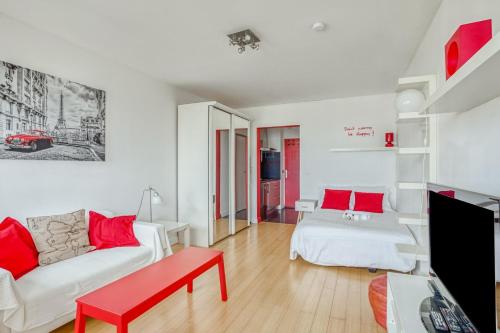 - un salon avec un canapé blanc et des oreillers rouges dans l'établissement GuestReady - Beau studio avec vue imprenable, à Paris