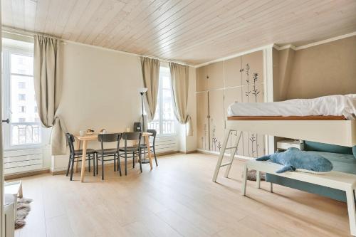 - une chambre avec des lits superposés, une table et des chaises dans l'établissement GuestReady - Lovely Minimalist Studio in Plaisance, à Paris