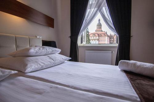 a bedroom with a large bed with a window at Hotel Zamkowy in Wałbrzych