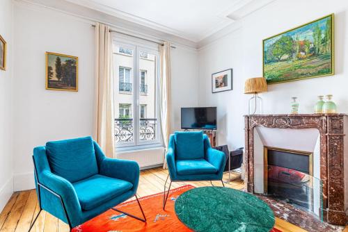 - un salon avec deux chaises bleues et une cheminée dans l'établissement GuestReady - Douceur Parisienne dans le 15e arr., à Paris