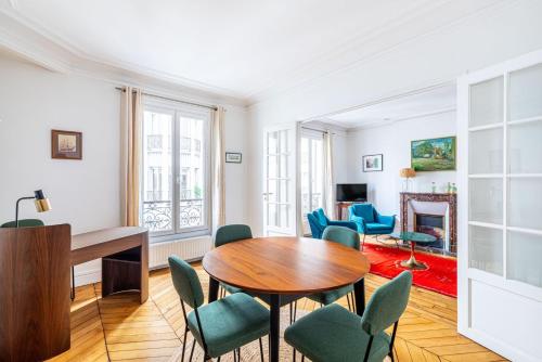 un salon avec une table et des chaises dans l'établissement GuestReady - Douceur Parisienne dans le 15e arr., à Paris