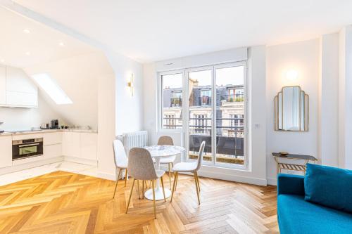 une cuisine et un salon avec une table et des chaises dans l'établissement GuestReady - Appartement Grenelle, à Paris