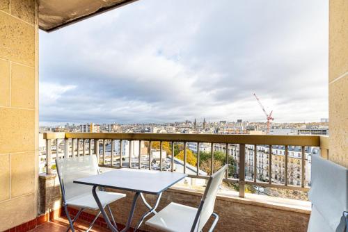 un balcon avec une table et des chaises et une vue dans l'établissement GuestReady - Studio Chic avec Vue Panoramique, à Paris