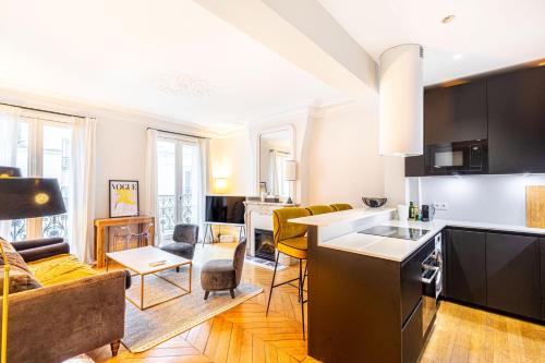 une cuisine et un salon avec un canapé et une table dans l'établissement GuestReady - Séjour de charme dans le 6ème, à Paris