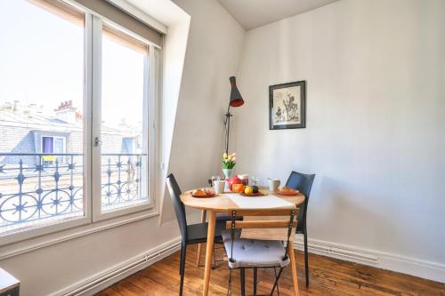 une salle à manger avec une table et des chaises et une fenêtre dans l'établissement GuestReady - Studio lumineux à Beaugrenelle, à Paris