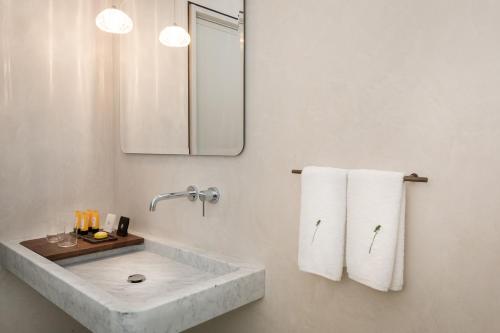 a bathroom with a sink and a mirror and towels at Locanda La Raia in Gavi