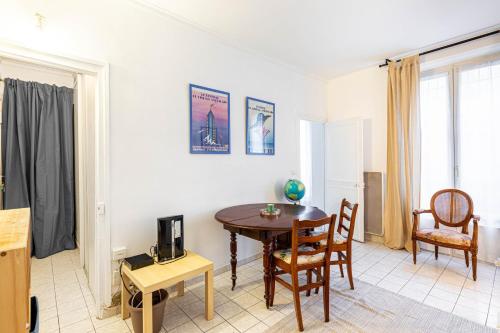 un salon avec une table et des chaises en bois dans l'établissement GuestReady - Modern Comfort near Montmartre, à Paris