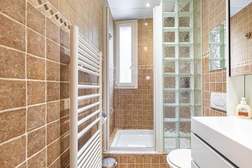 une salle de bain avec douche et toilettes dans l'établissement GuestReady - Charmant Appartement Lumineux, à Paris