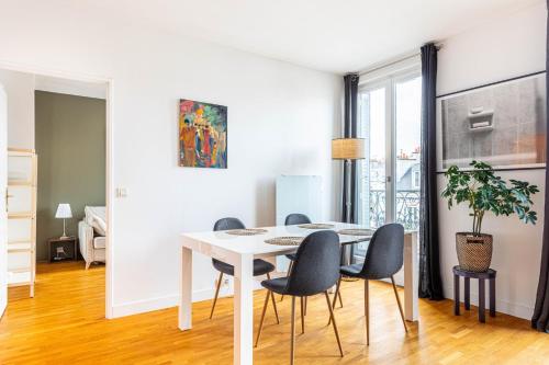 une salle à manger blanche avec une table et des chaises blanches dans l'établissement GuestReady - Charming stay near Palais Garnier, à Paris