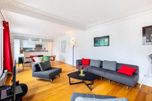 ein Wohnzimmer mit einem grauen Sofa und roten Kissen in der Unterkunft GuestReady - Modern Comfort near Champs de Mars in Paris