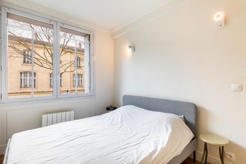 une chambre blanche avec un lit et une fenêtre dans l'établissement GuestReady - Appartement Chic et Élégant, à Paris