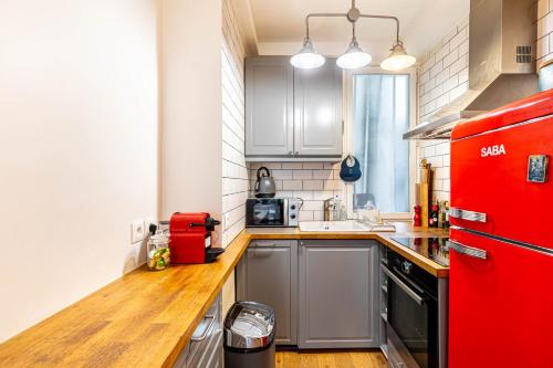 Il comprend une cuisine équipée d'un réfrigérateur rouge et d'un comptoir en bois. dans l'établissement GuestReady - Appartement Chic et Élégant, à Paris