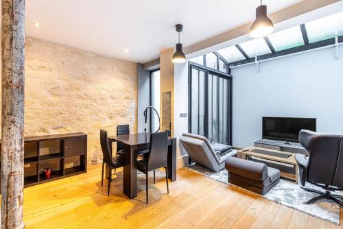 - un salon avec une table, des chaises et une télévision dans l'établissement GuestReady - Studio design et fonctionnel, à Paris