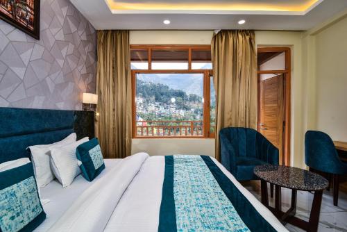 um quarto de hotel com uma cama e uma janela em Hotel Pawan Regency Mcleodganj em McLeod Ganj