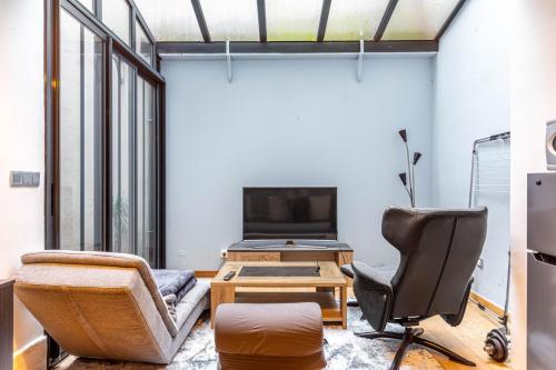 - un salon avec un fauteuil et une télévision dans l'établissement GuestReady - Studio design et fonctionnel, à Paris