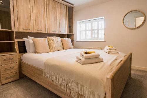 una camera da letto con un grande letto con asciugamani di Spacious & well decorated 4 bedroom home near Chester a Saughall