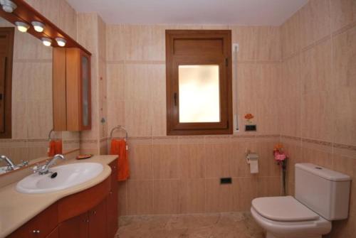 baño con aseo y lavabo y ventana en Villa ilusión BRAVA, en Lloret de Mar