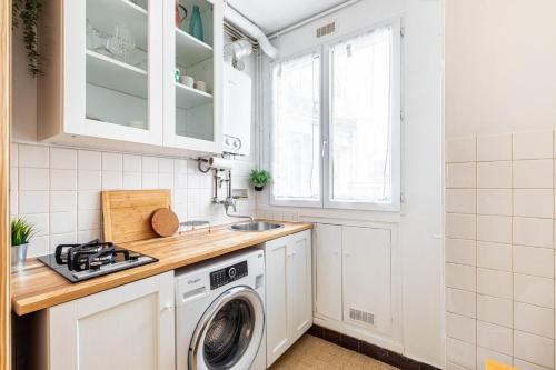 a kitchen with a washing machine and a sink at GuestReady - Luxury Living near Panthéon in Paris