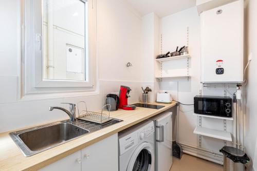 une cuisine avec un évier et une machine à laver dans l'établissement GuestReady - Séjour Confortable près de Montmartre, à Paris