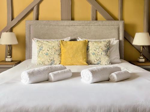 Una cama blanca con cuatro almohadas. en Black Buoy Inn, en Wivenhoe