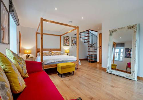 a bedroom with a canopy bed and a red couch at The Cider House - Launceston in Werrington