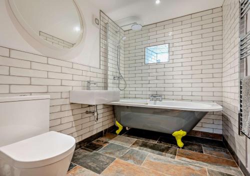 a bathroom with a tub and a toilet and a sink at The Cider House - Launceston in Werrington