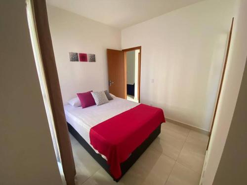 a bedroom with a bed with a red blanket at Lindo Apto Grande e Novíssimo no Centro in Juiz de Fora