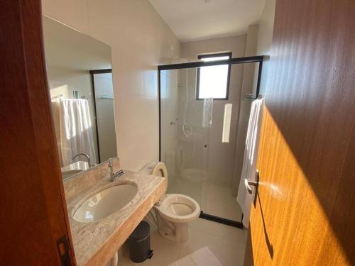 a bathroom with a sink and a toilet and a shower at Lindo Apto Grande e Novíssimo no Centro in Juiz de Fora