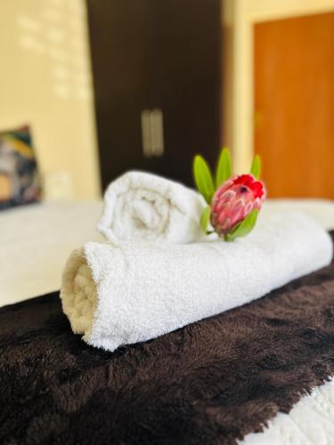 a towel with a flower on it on a bed at Lyndhurst in Margate