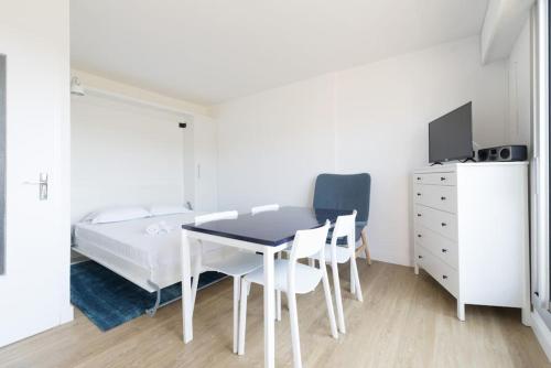 une chambre avec un lit, une table et des chaises dans l'établissement La Goélette à Préfailles - Studio 2 Personnes vue mer, parking, à Préfailles
