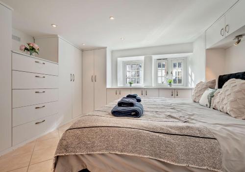 um quarto com uma cama grande e armários brancos em Pearl Cottage - St Agnes em St. Agnes 