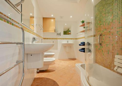 uma casa de banho com um lavatório, um WC e um chuveiro em Pearl Cottage - St Agnes em St. Agnes 