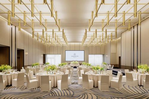 a conference room with tables and chairs and a projection screen at Sheraton Kagoshima in Kagoshima