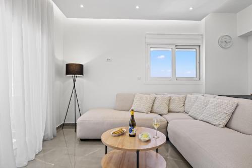 uma sala de estar branca com um sofá e uma mesa em Horizon View in Ilha de Rhodes