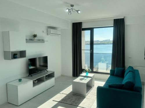 a living room with a blue couch and a television at Apartments in Solid House Mamaia in Mamaia