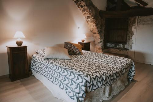 a bedroom with a bed in the corner of a room at Domaine de Tapies 2 gites jusqu à 19 personnes in Cornus