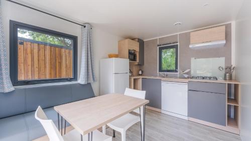 une cuisine et une salle à manger avec une table et des chaises dans l'établissement Camping Etennemare, à Saint-Valery-en-Caux