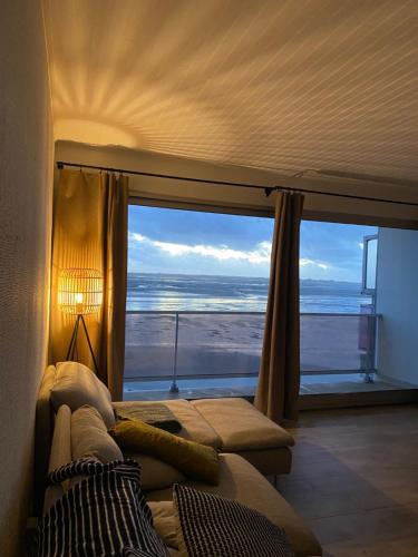 Cette chambre dispose d'une grande fenêtre offrant une vue sur l'océan. dans l'établissement VUE BAIE La Sauvagine 1, au Crotoy