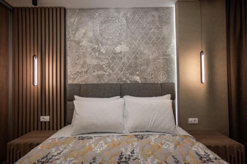 a bedroom with a bed with two lights on it at M3 in Kraljevo