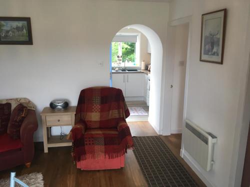 a living room with a couch and a chair at Ruthven House Holiday Cottages in Kingussie