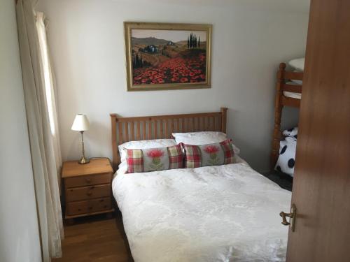 a bedroom with a bed and a picture on the wall at Ruthven House Holiday Cottages in Kingussie