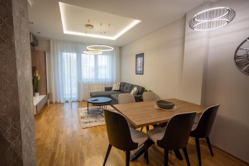 a dining room and living room with a table and chairs at M3 in Kraljevo